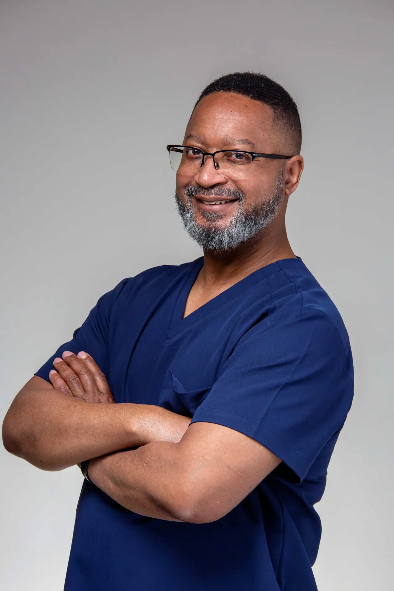 Provider in navy blue scrubs arms folded